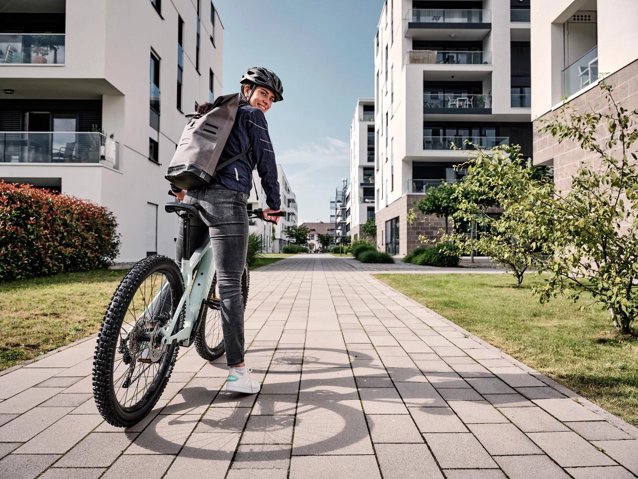 Eine JobRadlerin mit Mountainbike in einer Häuserschlucht